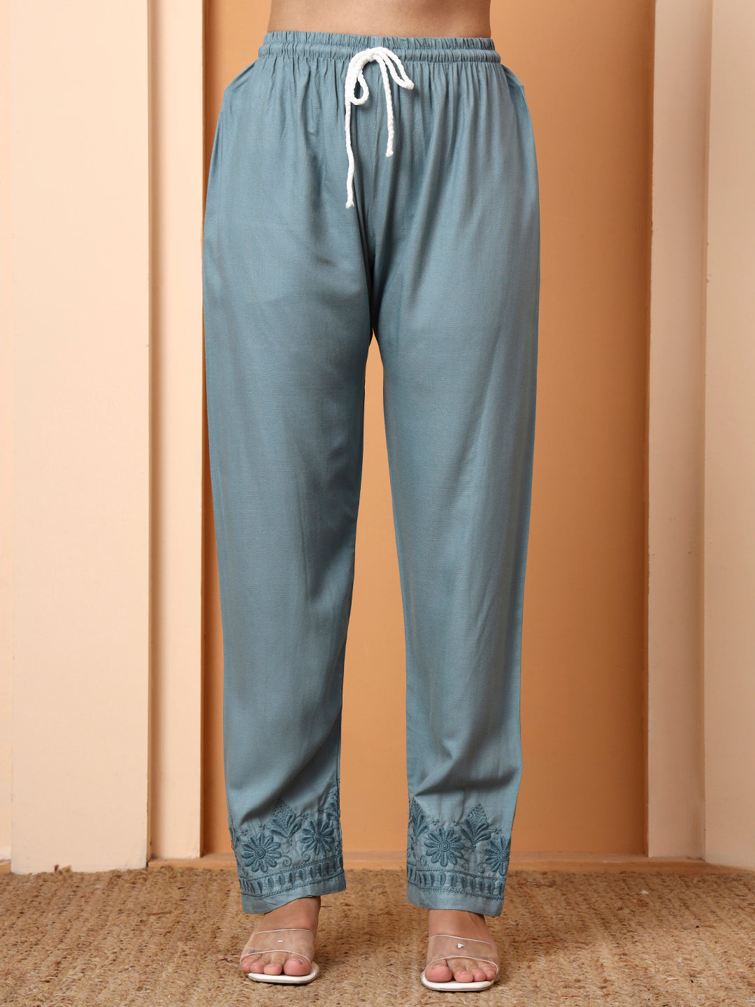 Matching pants with a drawstring waist on a beige background