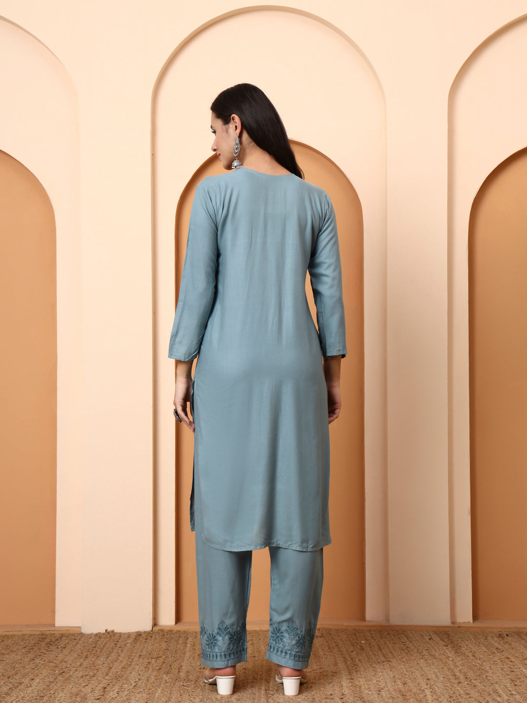 Woman wearing a light green kurta with pants in an archway setting