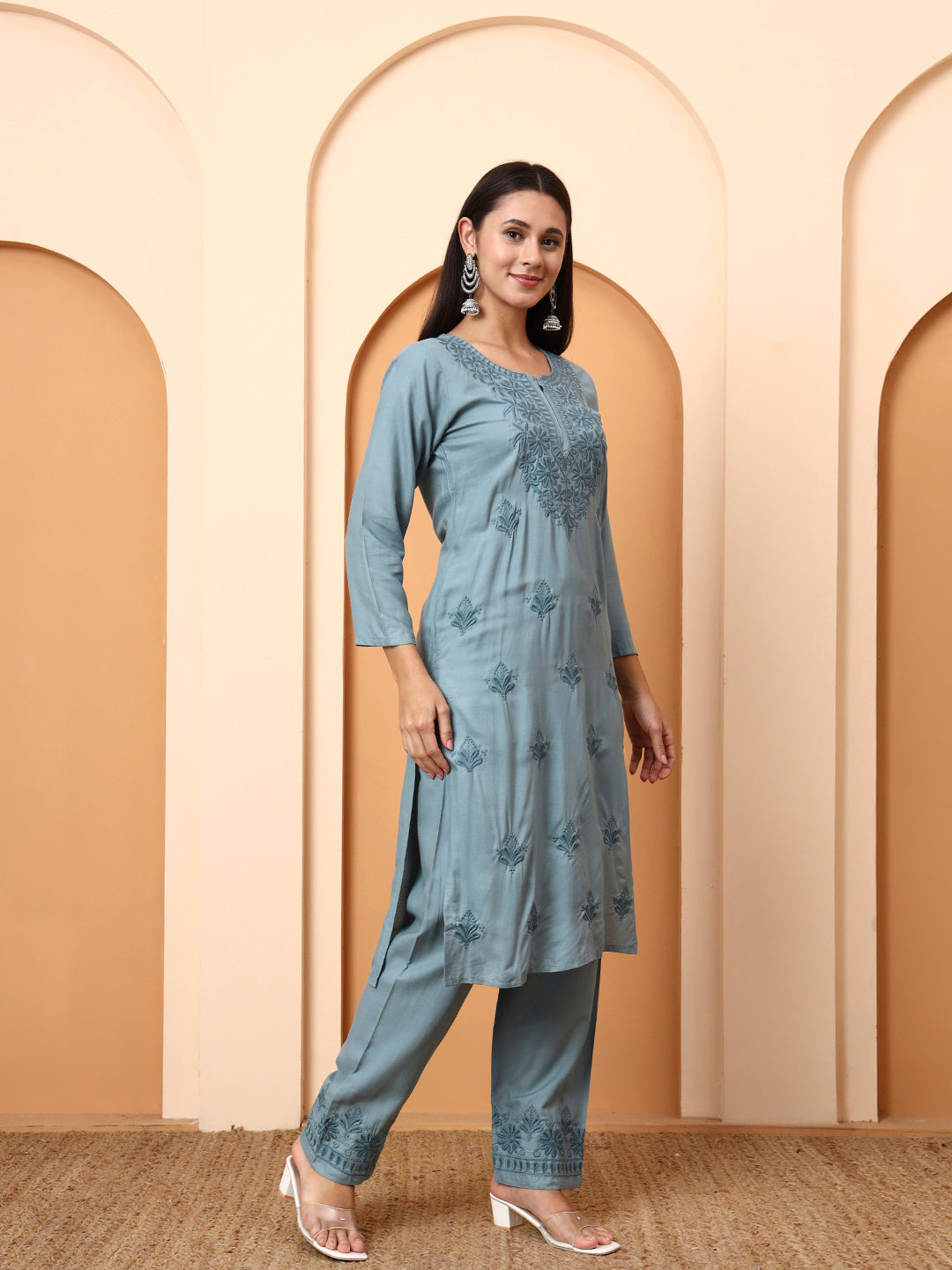 Woman wearing a Green kurta with pants in a beige archway setting