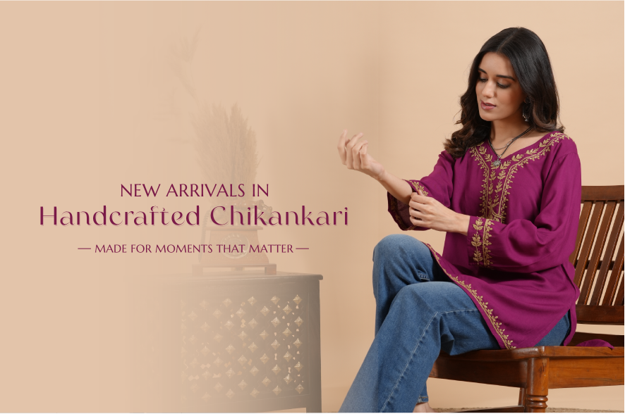 Woman wearing a handcrafted Chikankari outfit sitting on a wooden stool with a beige background.